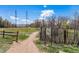 Dirt path surrounded by a wooden fence, foliage and a sign showing the trail map of South Platte Park at 2812 W Davies Dr, Littleton, CO 80120