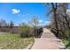 Scenic view of a nature trail with lush greenery, a small bridge, and beautiful sky, ideal for outdoor activities at 2812 W Davies Dr, Littleton, CO 80120