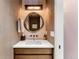 Stylish powder room featuring an illuminated round mirror, modern sink, and elegant wallpaper at 203 Garfield St, Denver, CO 80206