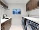 Well-appointed laundry room with modern washer and dryer, ample counter space, and stylish cabinetry for organization at 203 Garfield St, Denver, CO 80206