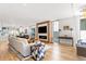 Open living room with a large sofa, fireplace, media center, hardwood floors, and dining area in background at 203 Garfield St, Denver, CO 80206