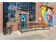 Brick building exterior with a blue door, colorful mural, and unique architectural details at 2721 Curtis St, Denver, CO 80205