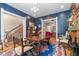 Elegant dining room featuring hardwood floors, large windows, dark blue walls, and vintage furnishings at 2721 Curtis St, Denver, CO 80205