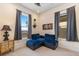 Cozy sitting room with a comfortable blue couch, vintage decor, and natural light from two windows at 2721 Curtis St, Denver, CO 80205
