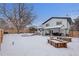 Large backyard with wooden raised garden beds and snow at 7513 E Bates Dr, Denver, CO 80231