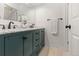 Modern bathroom with double vanity, marble countertop, and dark green cabinets at 7513 E Bates Dr, Denver, CO 80231