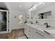 Modern bathroom with double vanity, marble countertop, and walk-in closet at 7513 E Bates Dr, Denver, CO 80231