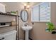 Small bathroom with pedestal sink, toilet, and shelving at 7513 E Bates Dr, Denver, CO 80231