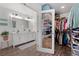 White bathroom with double vanity, marble countertop and large closet at 7513 E Bates Dr, Denver, CO 80231