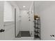 Shower with white subway tile, hexagon floor tile, and glass door at 7513 E Bates Dr, Denver, CO 80231