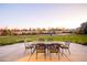 Inviting backyard patio with comfortable dining furniture offers scenic views of the lawn and community playground at 2258 Front Range Rd, Erie, CO 80516