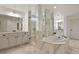 Bright bathroom featuring a soaking tub, glass shower, marble accents, and white cabinetry at 2258 Front Range Rd, Erie, CO 80516