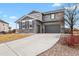 Inviting two-story home features a stone facade, an attached two car garage and a large driveway at 2258 Front Range Rd, Erie, CO 80516