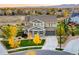 Charming two-story home with gray exterior, stone accents, lush landscaping, and a well-manicured front yard at 2258 Front Range Rd, Erie, CO 80516