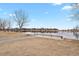 Picturesque lake view with a dock and bench seating surrounded by a natural shoreline and blue skies at 2258 Front Range Rd, Erie, CO 80516