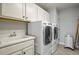 Functional laundry room with modern LG washer and dryer, white cabinetry, and a utility sink at 2258 Front Range Rd, Erie, CO 80516