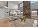 Elegant living room featuring a soaring stone fireplace, a comfortable sofa, and abundant natural light at 2258 Front Range Rd, Erie, CO 80516
