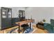 Modern office with sleek desk, custom cabinets, and colorful rug on hardwood floors at 2258 Front Range Rd, Erie, CO 80516