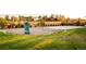 Community playground features a slide, swings, and bench seating amidst a grassy landscape and colorful foliage at 2258 Front Range Rd, Erie, CO 80516