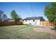 Large backyard with a wooden fence, newly painted exterior, and green grass, offering a private outdoor space at 7870 Magnolia St, Commerce City, CO 80022