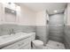 Bathroom featuring a walk-in shower with floor-to-ceiling tile and a modern vanity sink at 7870 Magnolia St, Commerce City, CO 80022