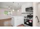 Modern kitchen with white cabinetry, stainless steel appliances, and stylish pendant lighting at 7870 Magnolia St, Commerce City, CO 80022