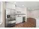 Modern kitchen featuring stainless steel appliances, sleek white cabinets, and elegant subway tile backsplash at 7870 Magnolia St, Commerce City, CO 80022