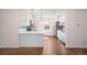 Bright kitchen with white cabinets, stainless steel appliances, and an open layout to the living area at 7870 Magnolia St, Commerce City, CO 80022