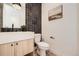 Stylish powder room with chic black tile accent wall, modern fixtures, and white vanity at 372 S Humboldt St, Denver, CO 80209