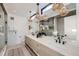 Bright bathroom featuring double vanity with modern light fixtures and a walk-in shower at 372 S Humboldt St, Denver, CO 80209