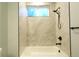 Modern bathroom with new tile, new fixtures, tub and shower with glass door and bright light at 1450 Syracuse St, Denver, CO 80220