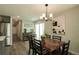Open dining room showcases wood floors, modern lighting, and flows into the kitchen with stainless steel appliances at 1450 Syracuse St, Denver, CO 80220