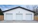 This is a detached three-car garage with white doors and siding at 1450 Syracuse St, Denver, CO 80220