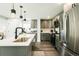 Bright kitchen features gray cabinets, stainless steel appliances, and a spacious island with modern lighting fixtures at 1450 Syracuse St, Denver, CO 80220