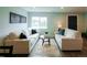 Relaxing living room showcasing neutral colored sofas, modern art, a glass-topped coffee table and ample light at 1450 Syracuse St, Denver, CO 80220