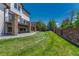 Spacious backyard featuring a well-maintained lawn, mature trees, and a charming stone patio at 9343 Vista Hill Ln, Lone Tree, CO 80124