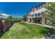 Expansive backyard featuring lush green lawn, mature trees, and a well-maintained brick perimeter at 9343 Vista Hill Ln, Lone Tree, CO 80124
