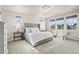 Bright primary bedroom featuring a decorative light fixture, large windows, and neutral carpet at 9343 Vista Hill Ln, Lone Tree, CO 80124