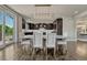 A dining room with modern lighting, a large table with seating, and views of the kitchen for seamless entertaining at 9343 Vista Hill Ln, Lone Tree, CO 80124
