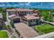 Stunning home with a clay tile roof, stone accents, a brick driveway and lush landscaping at 9343 Vista Hill Ln, Lone Tree, CO 80124