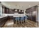 A modern kitchen features dark cabinetry, stainless steel appliances, and a large island with seating for a sleek design at 9343 Vista Hill Ln, Lone Tree, CO 80124