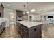 Bright kitchen featuring an island with white countertops, pendant lighting, and views into the dining and living areas at 9343 Vista Hill Ln, Lone Tree, CO 80124