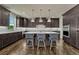 A modern kitchen with dark cabinets, a spacious island with seating, and sleek countertops offers a stylish culinary space at 9343 Vista Hill Ln, Lone Tree, CO 80124