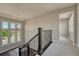 Second floor landing showcasing rod iron spindles, a light fixture, and view of neighborhood through windows at 9343 Vista Hill Ln, Lone Tree, CO 80124