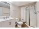 A modern bathroom features a glass-enclosed shower and sleek white fixtures at 10487 Panther Trce, Lone Tree, CO 80124