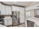 A modern kitchen showcasing stainless steel refrigerator and white cabinetry with complementing quartz countertops at 10487 Panther Trce, Lone Tree, CO 80124