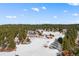 Aerial of home featuring a contemporary house, barn, pond, and wooded land at 367 Sandy Hollow Trl, Franktown, CO 80116