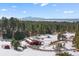Picturesque view of snow covered acreage with barn, trees, and mountains in the distance at 367 Sandy Hollow Trl, Franktown, CO 80116