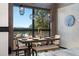 This dining room has a rustic wood table, brick wall, and mountain views from the window at 367 Sandy Hollow Trl, Franktown, CO 80116