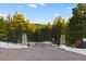 Private property gate with stone pillars set amongst the trees and snow covered ground at 367 Sandy Hollow Trl, Franktown, CO 80116